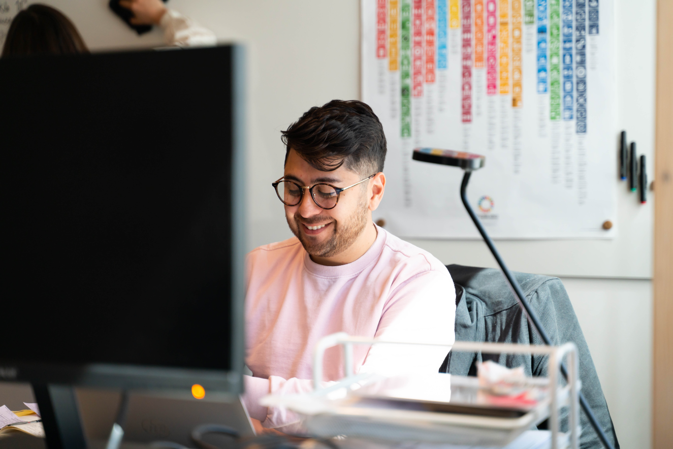 Light image with a guy happily working on a computer
