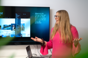 Woman presenting work to client with a presentation on a large screen
